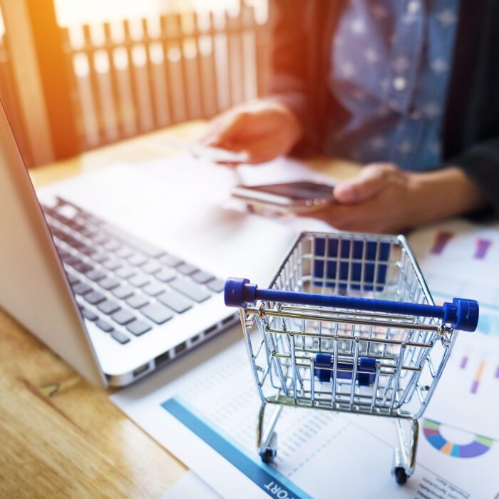 Cropped image of woman inputting card information and key on phone or laptop while shopping online.
